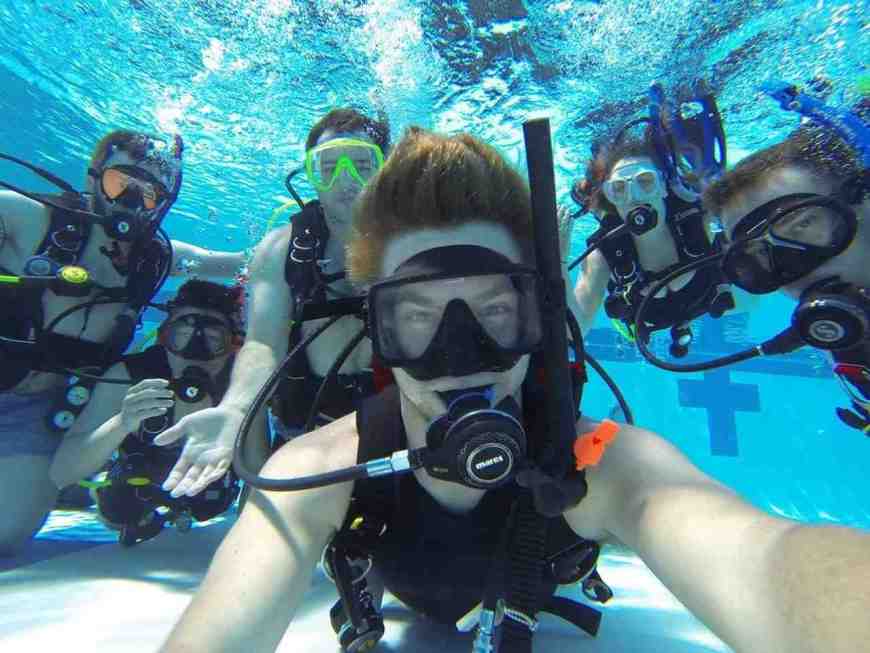 Curso de buceo con alumnos disfrutando y sacandosé fotos debajo del agua