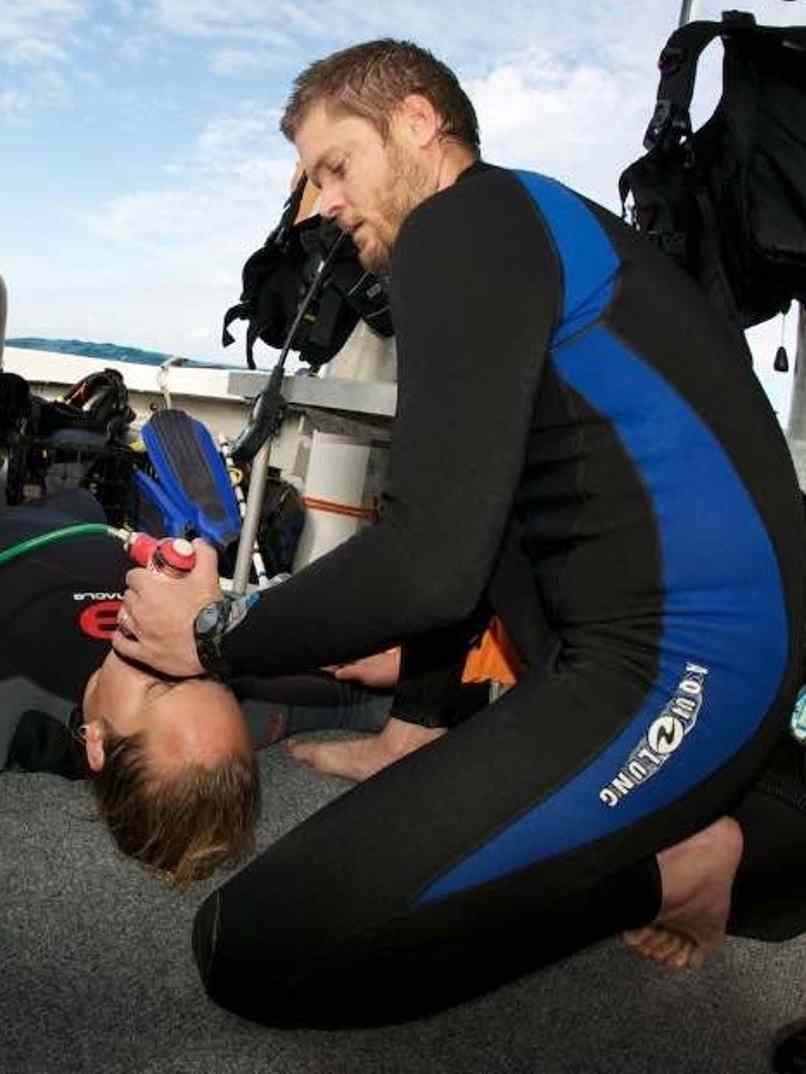 Instructor brindando oxígeno a un buceador accidentado