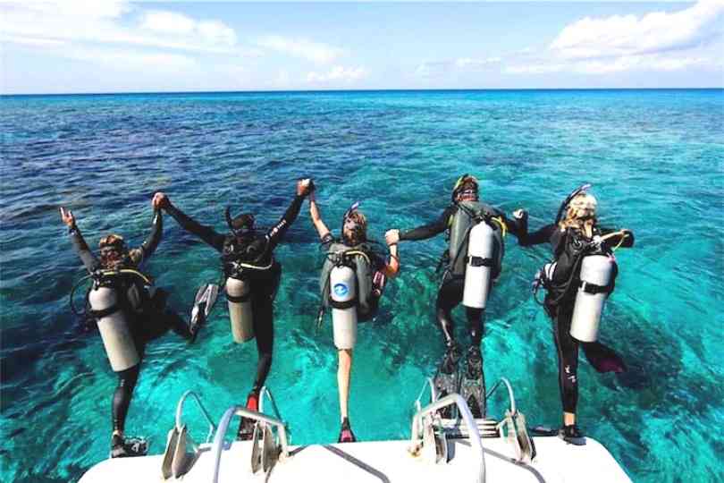 Buceadores entrando al agua desde el barco de buceo